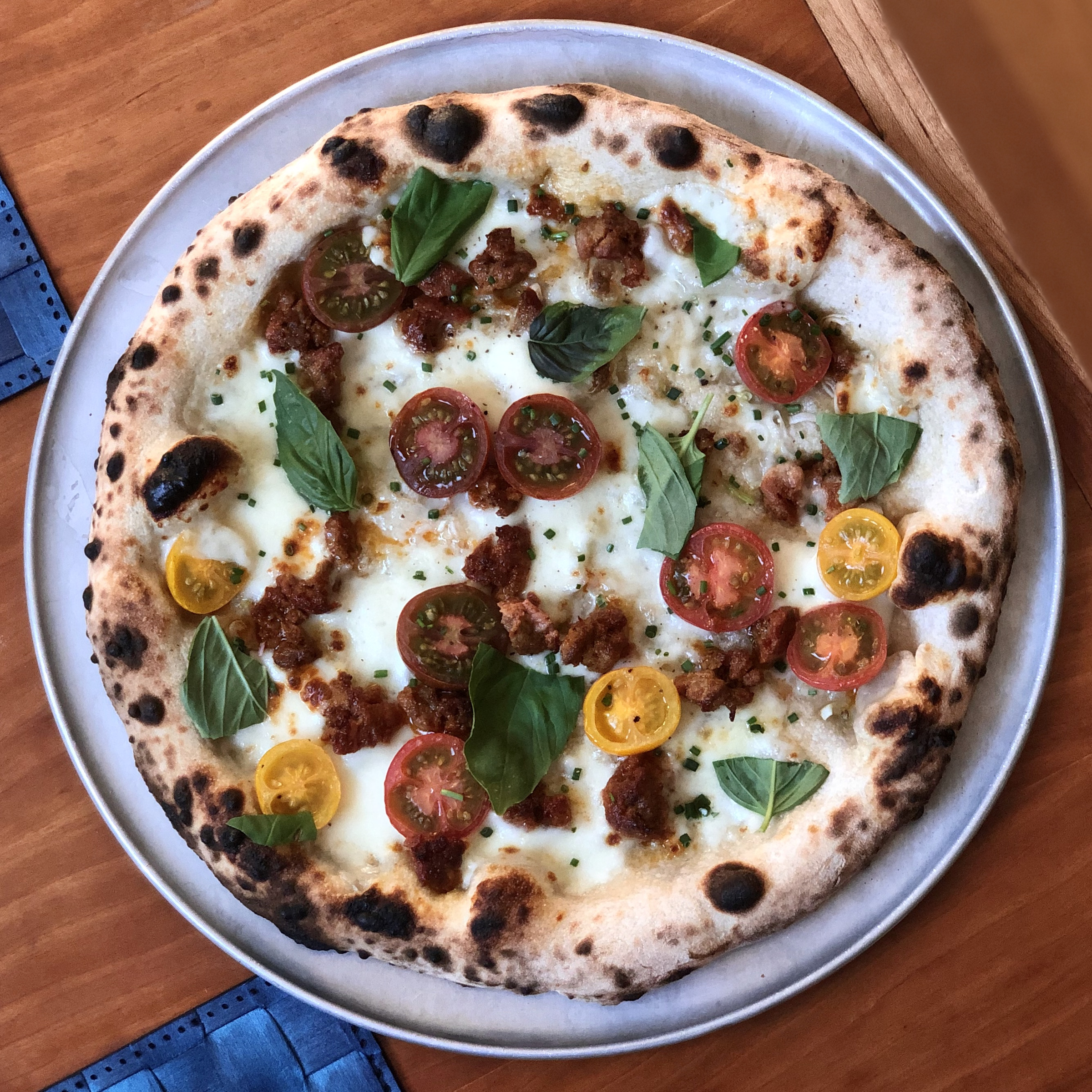 Pizza with smoked sausage, cherry tomatoes, dried chilli, jalapeno